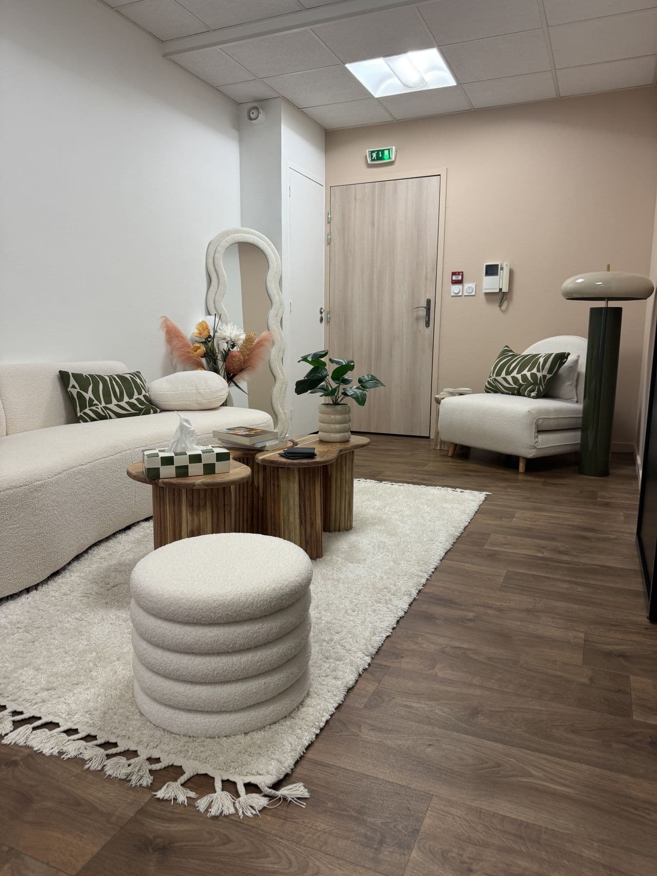 Lounge de Collab Studio avec canapé, tapis et tables en bois